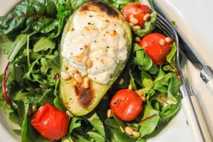 Goat's cheese filled avocados with salad and roasted cherry tomatoes