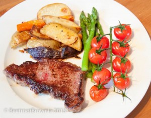 Steak with potato and carrot wedges, steamed asparagus and roasted cherry tomatoes